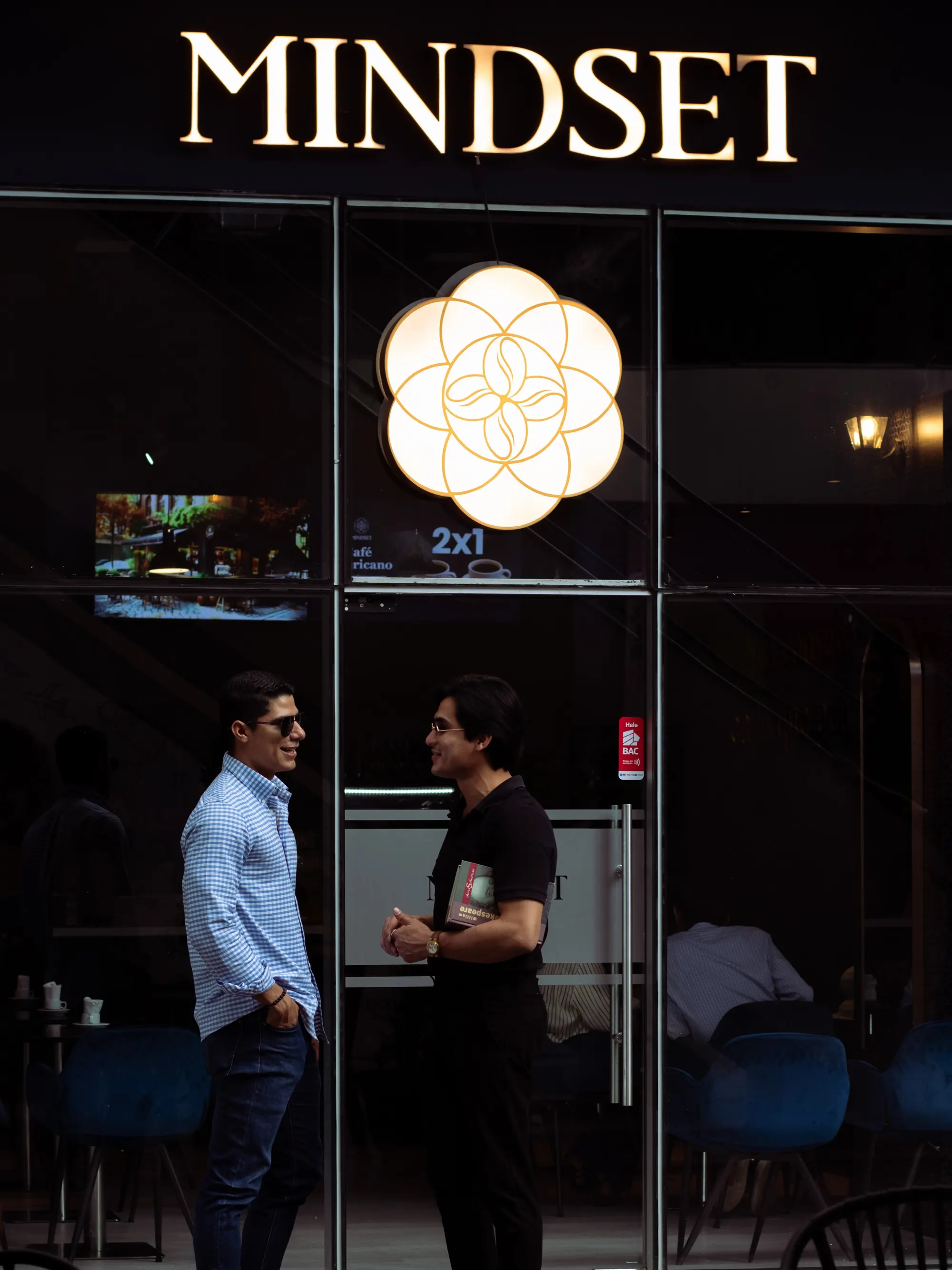 Fachada de Mindset con el rótulo dorado y la flor de la vida iluminada