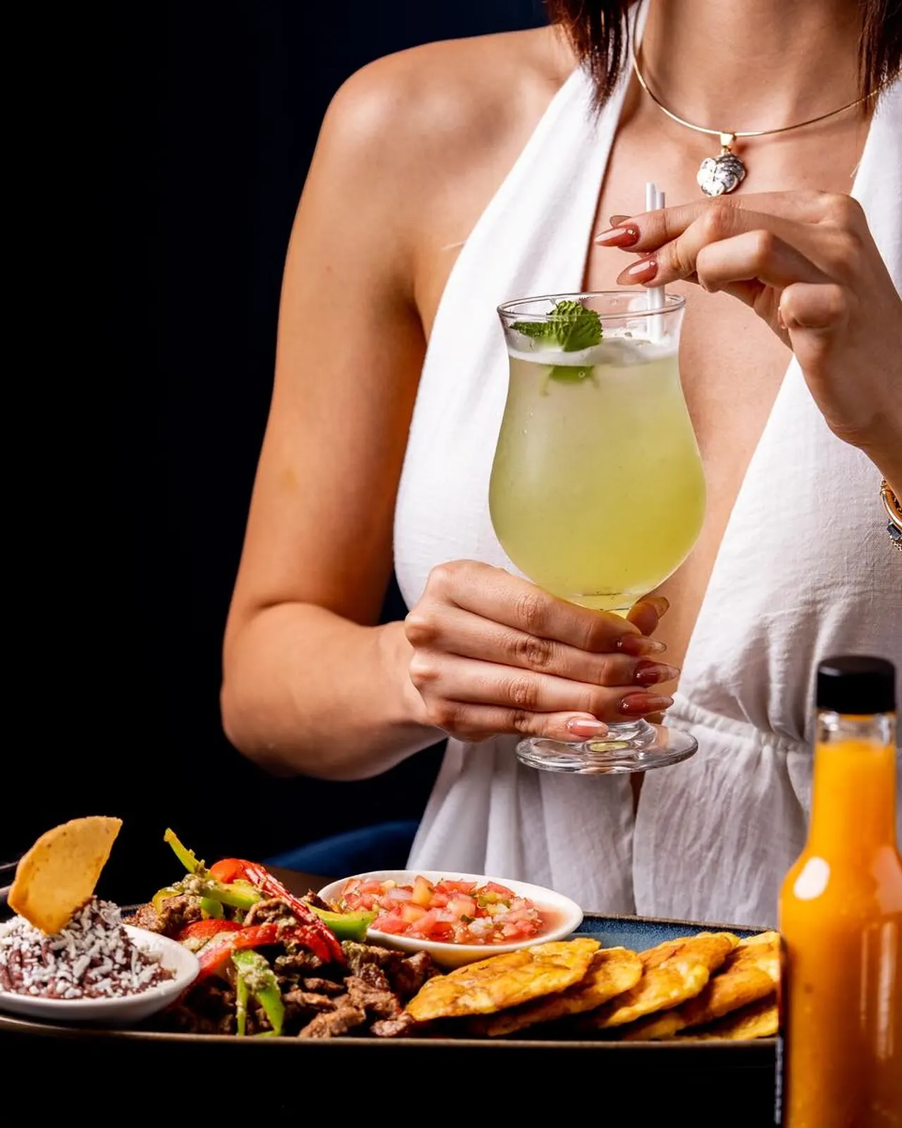 Limonada con hierbabuena servida sobre una mesa con tostones
